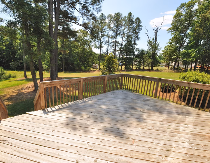 A timber deck overlooking an open grassed yard