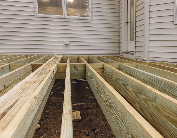 A deck restoration in progress, old boards removed to reveal the frame underneath