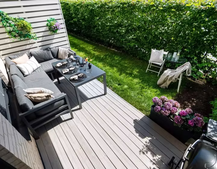 A low-profile ground-level composite deck with outdoor lounge seating