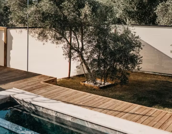 A timber deck bordering a swimming pool